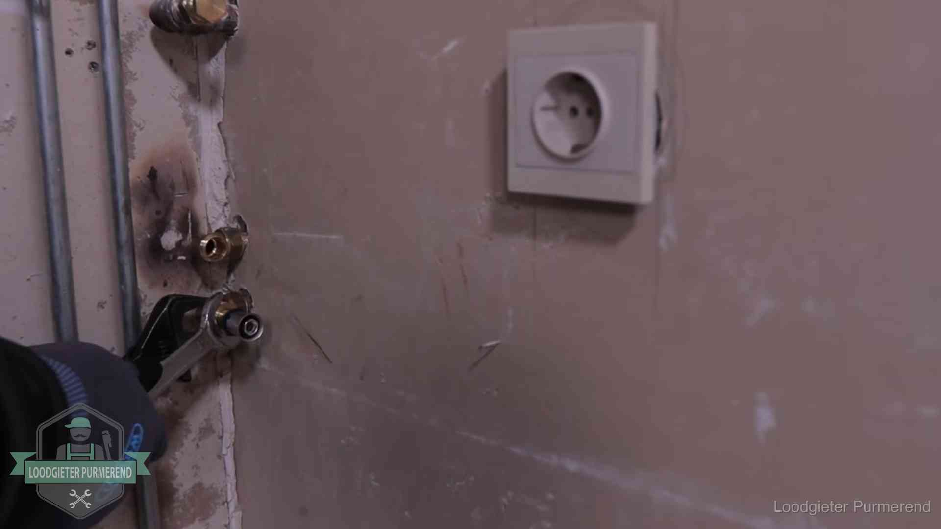 Monteur draait een perskoppeling vast op een leidingaansluiting in Purmerend