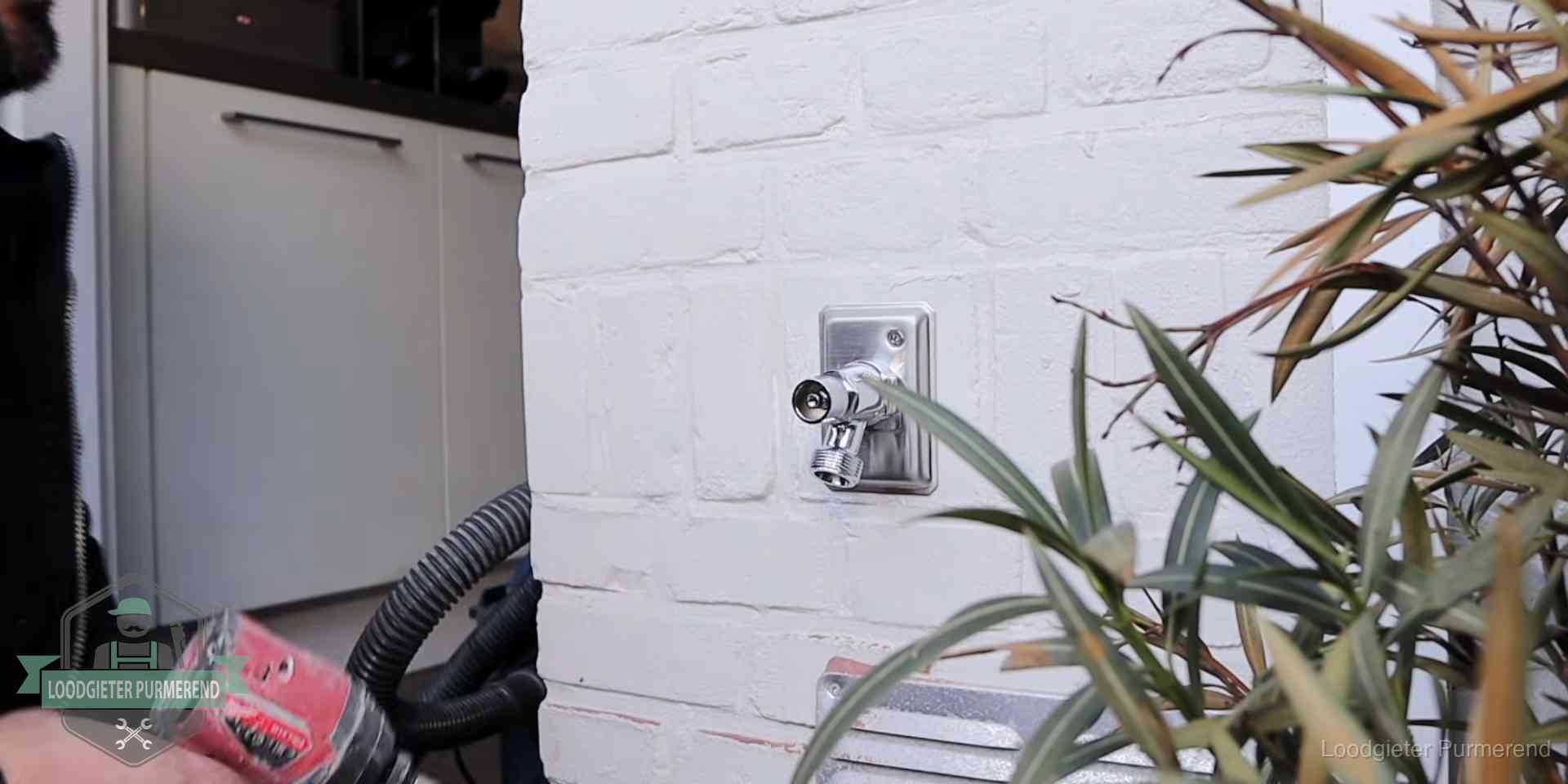 Chromen kraan op een muurplaat bij een woning in Purmerend, dichtdraaien is stap een van de lektest
