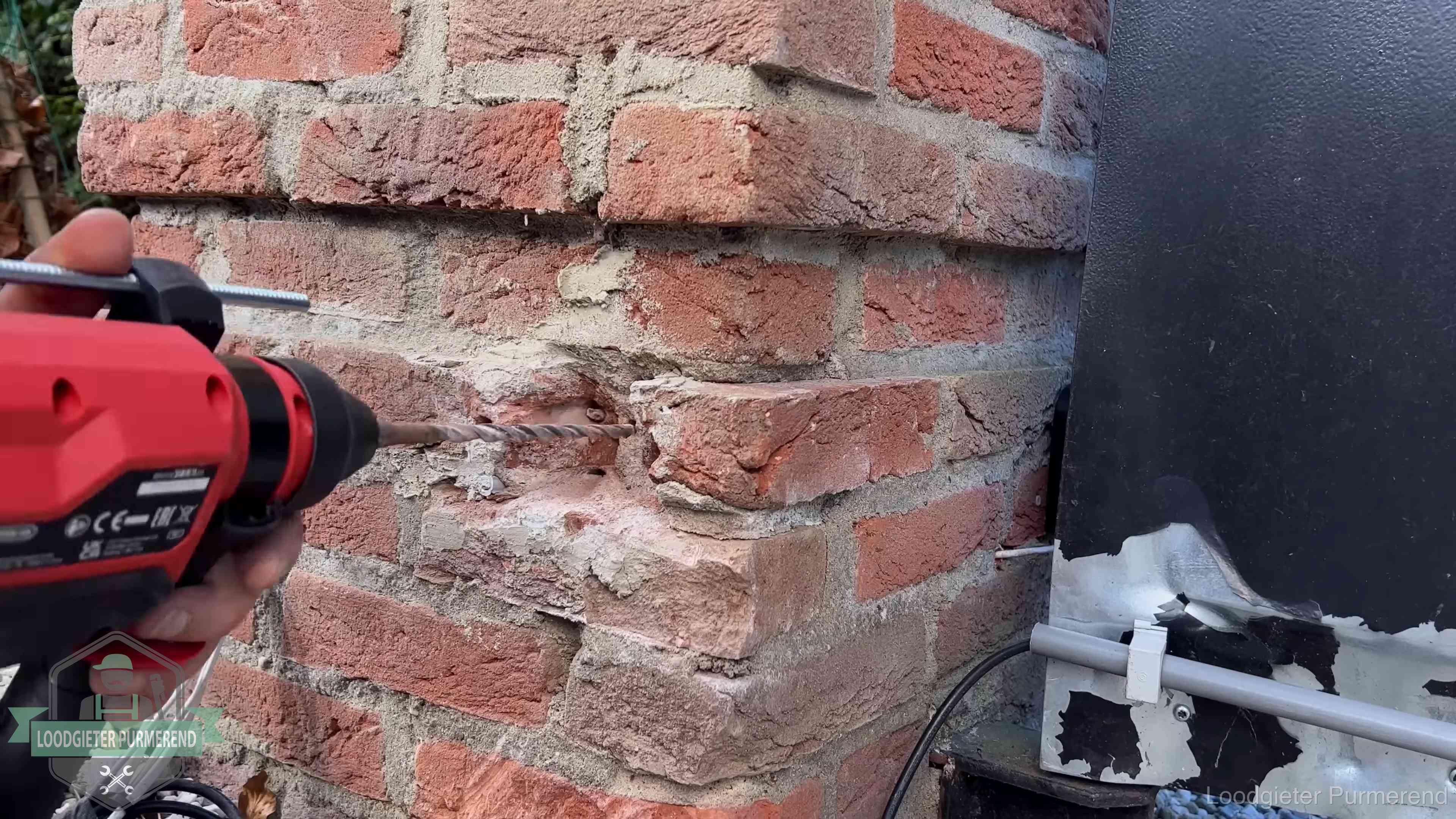 Vakman boort in de buitenmuur van een woning in de regio Purmerend