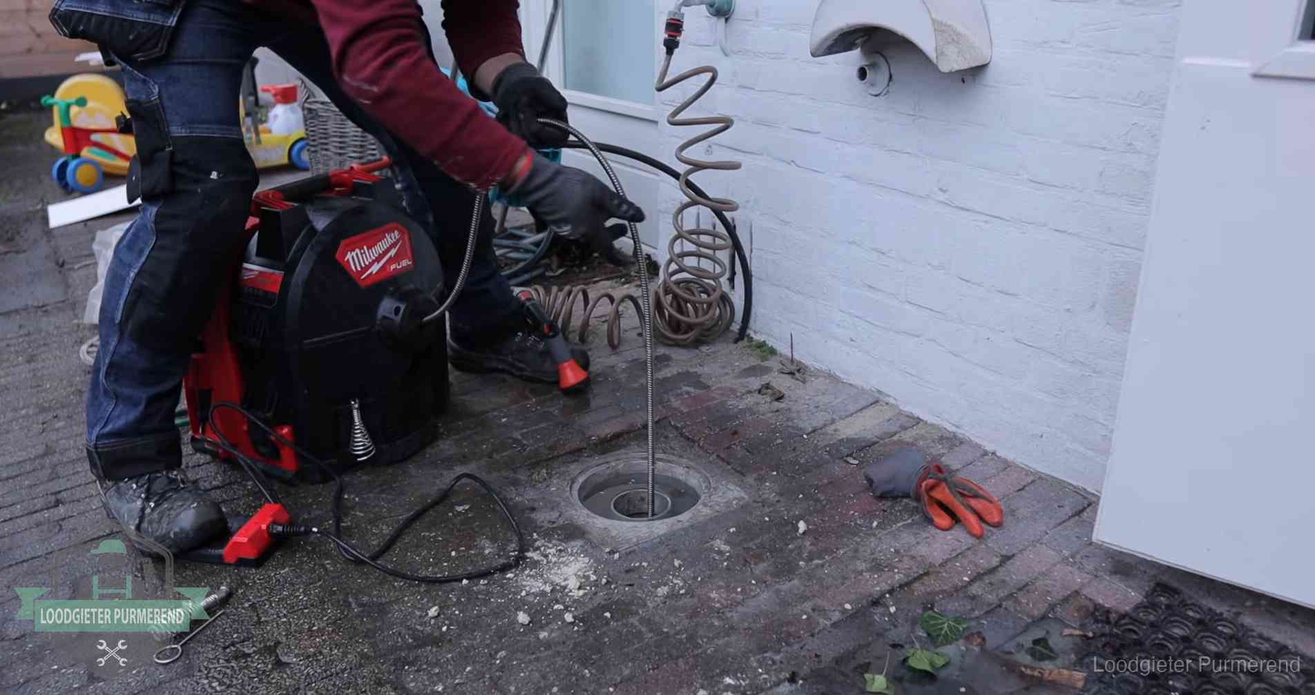 Erfgrens en gemeenteriool in Purmerend Ontstoppingsputje in de bestrating naast de gevel van een woning in Purmerend