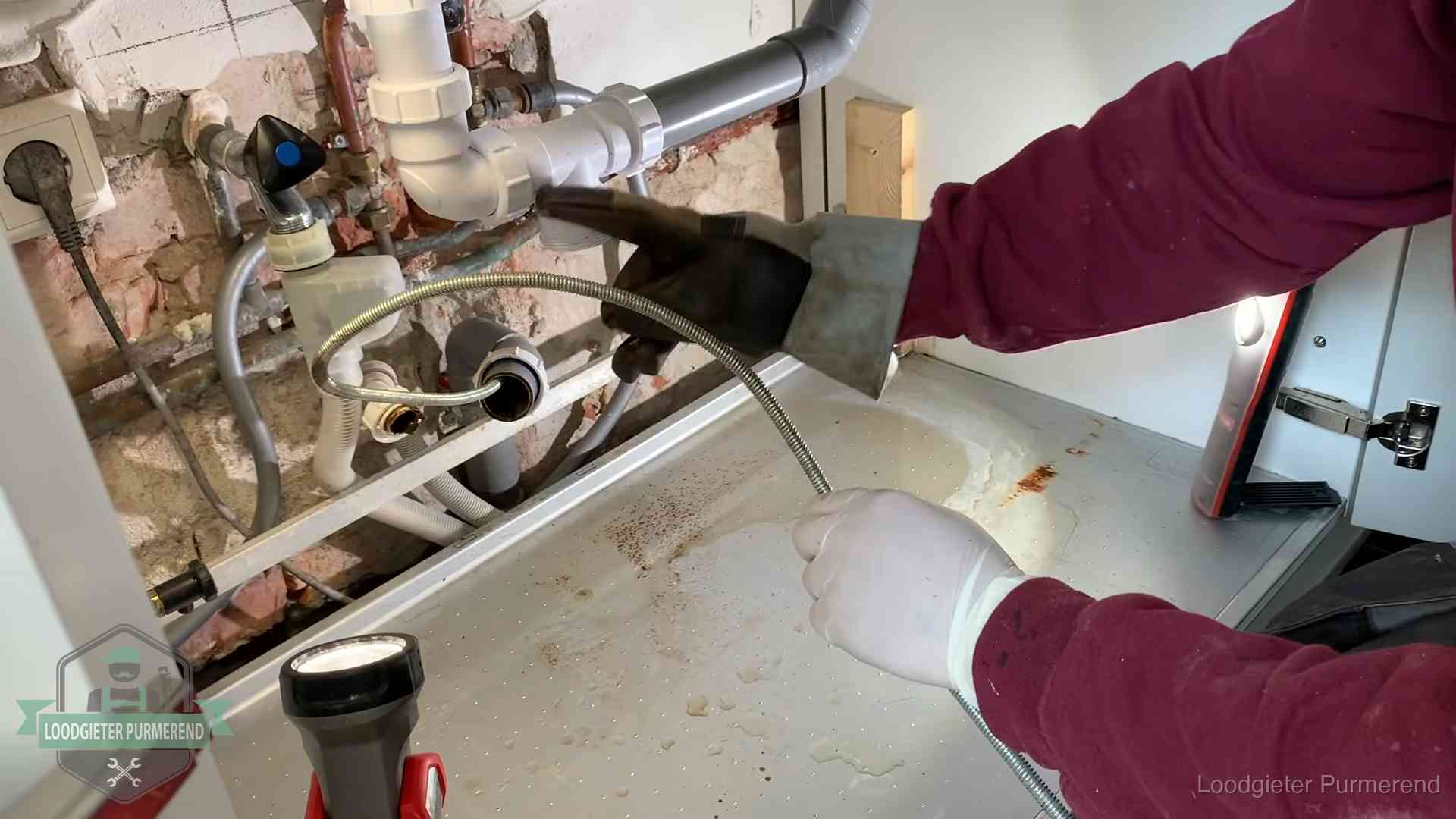 Spiraal of hogedruk in Purmerend Ontstoppingsveer gaat in een geopende sifonaansluiting onder het aanrecht in Purmerend