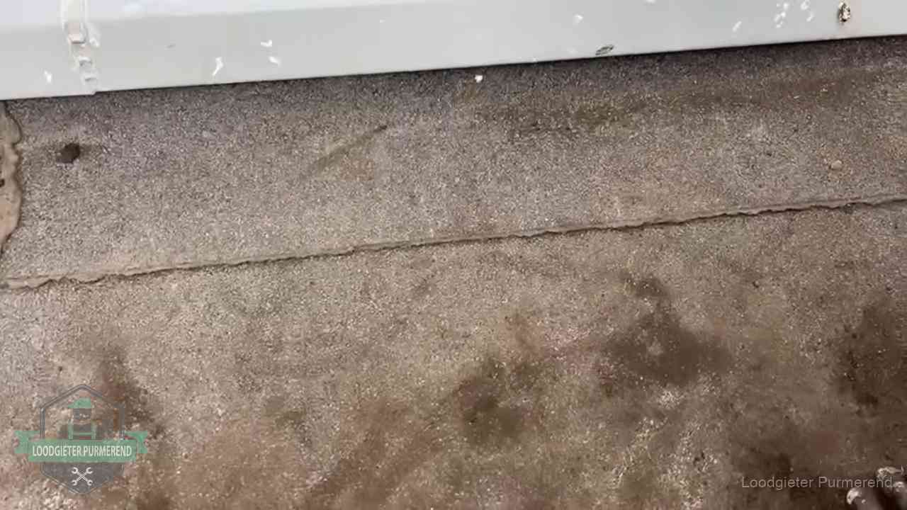 Vochtplekken bij de naad van een plat dak na aanhoudende regen in Purmerend