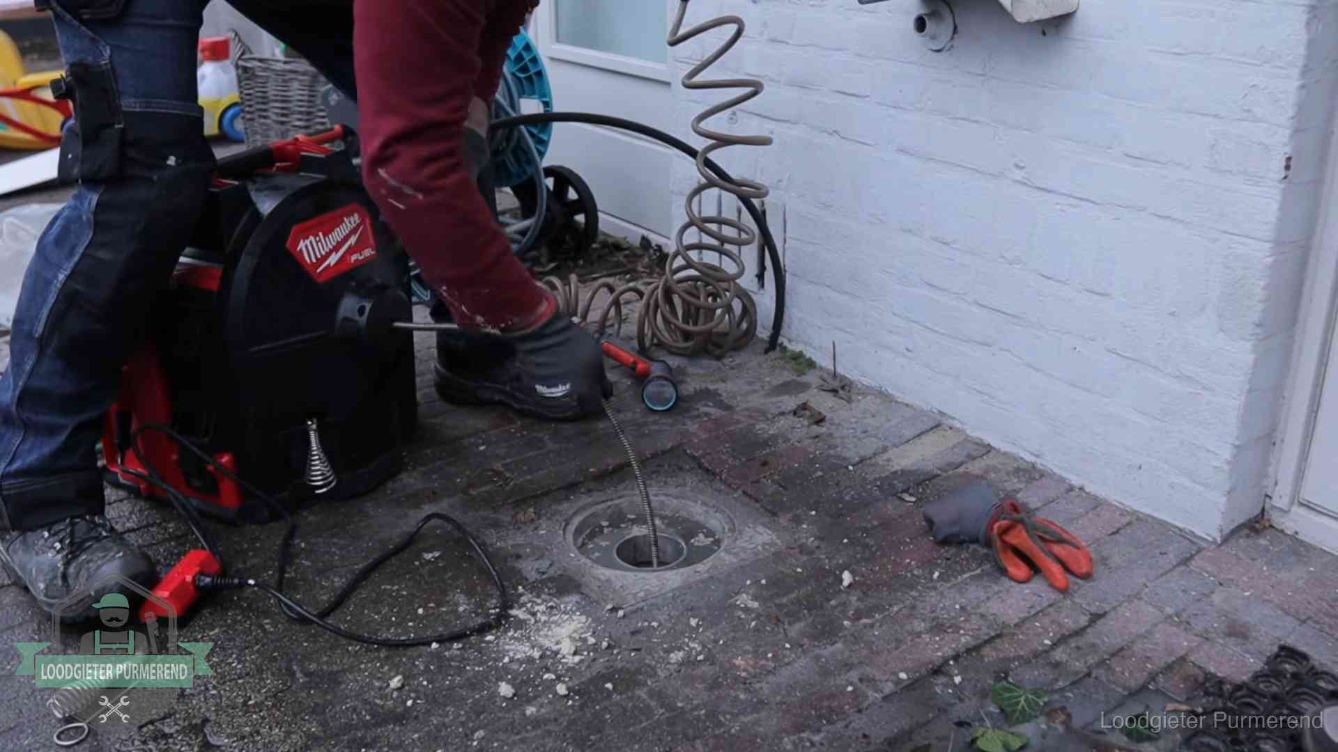 Prijs van een rioolontstopping in Purmerend Spiraalmachine bij een ontstoppingsputje in de bestrating in Purmerend