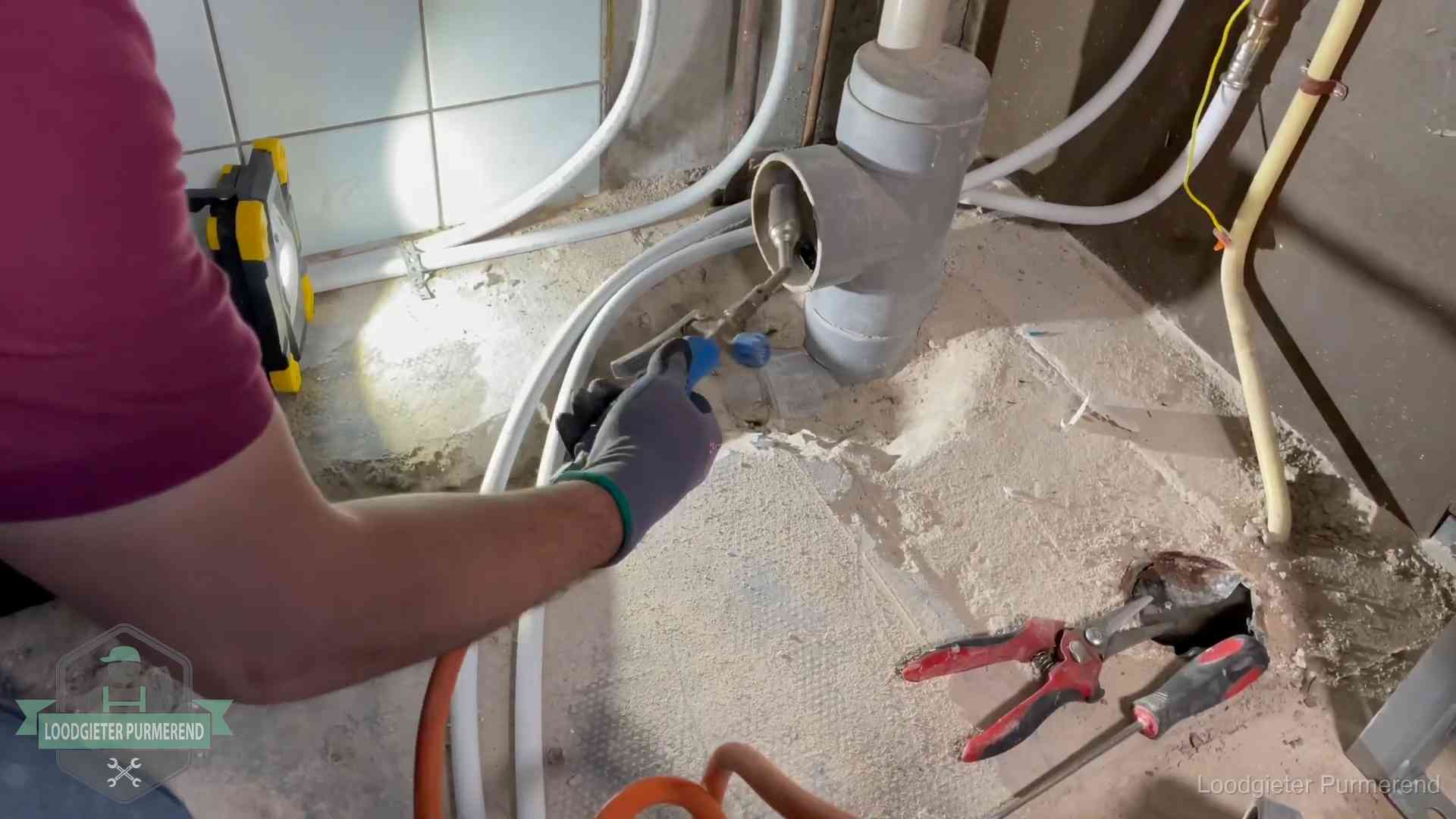 Loodgieter werkt aan leidingen bij een pvc-standleiding in een appartement in Purmerend
