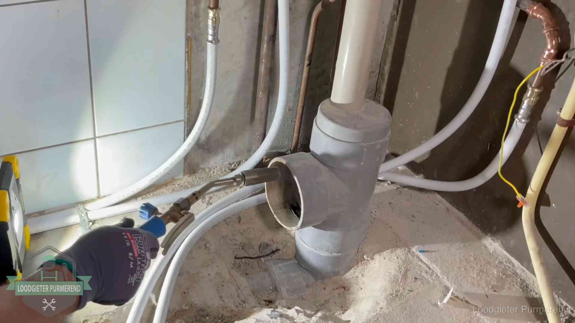 Verstopping in een huurwoning in Purmerend Loodgieter werkt aan leidingen bij de pvc-standleiding van een huurwoning in Purmerend
