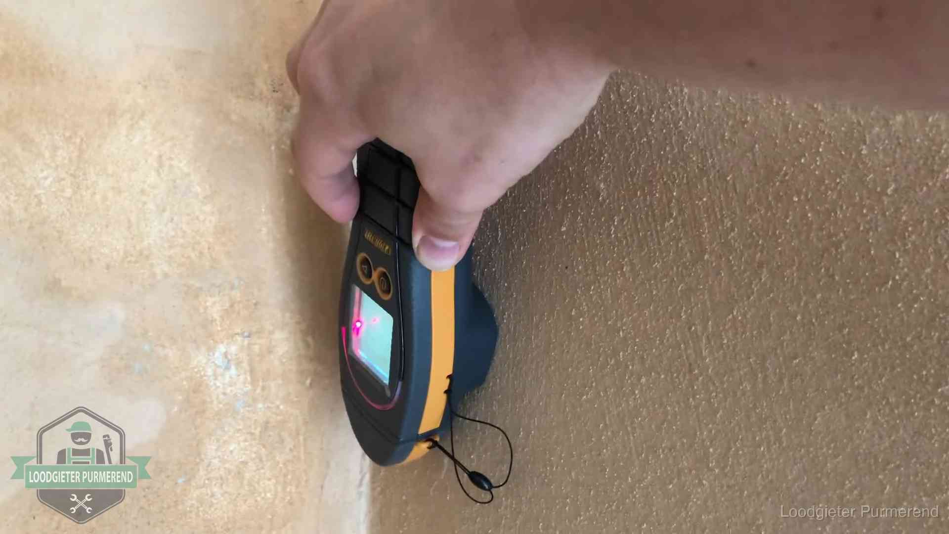 Vochtmeter tegen een muur met vochtplekken tijdens het opsporen van een daklekkage in Purmerend