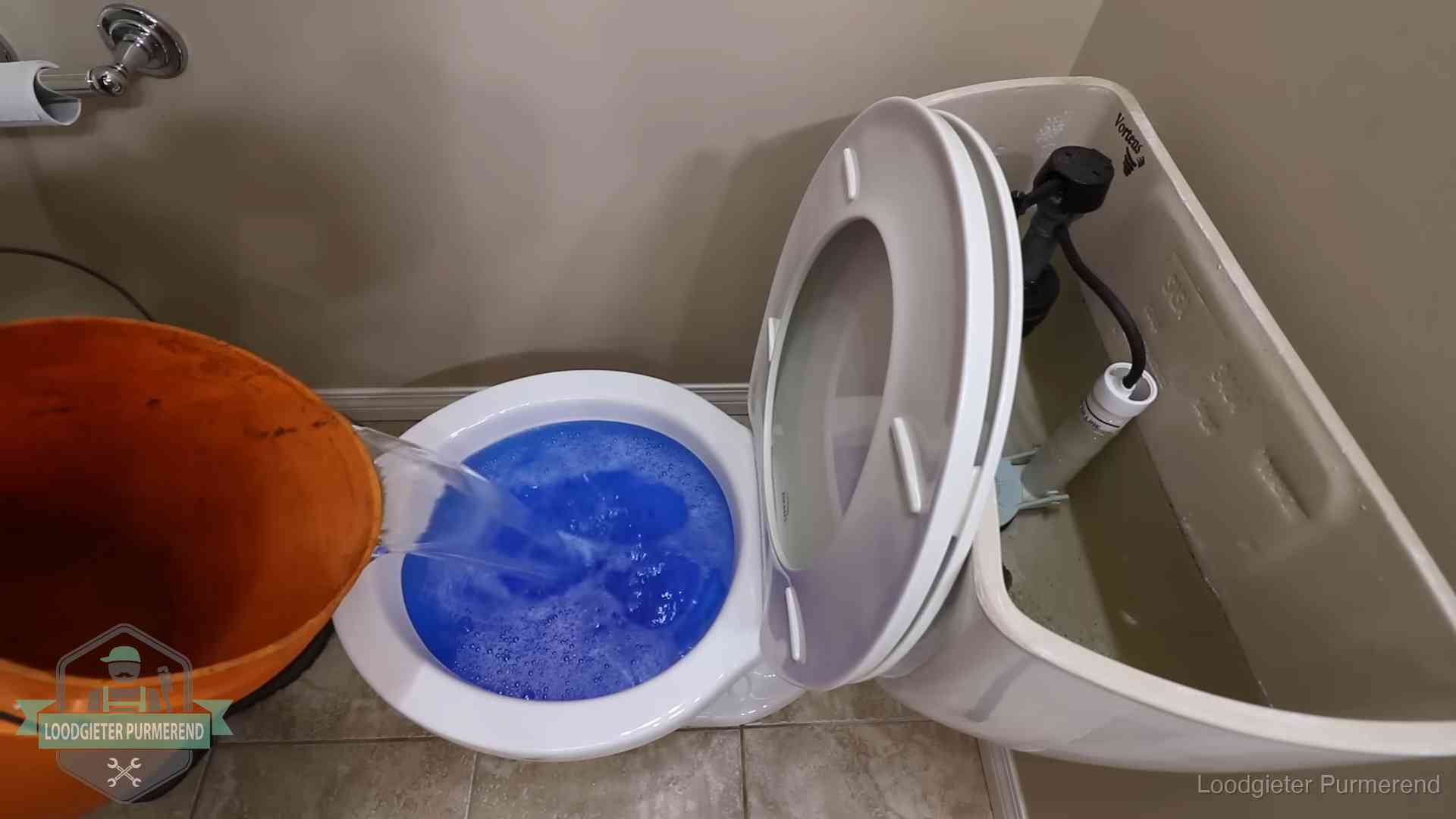 Water komt omhoog in de wc in Purmerend Water bij de wc-pot wordt met een emmer weggewerkt om schade te beperken in Purmerend